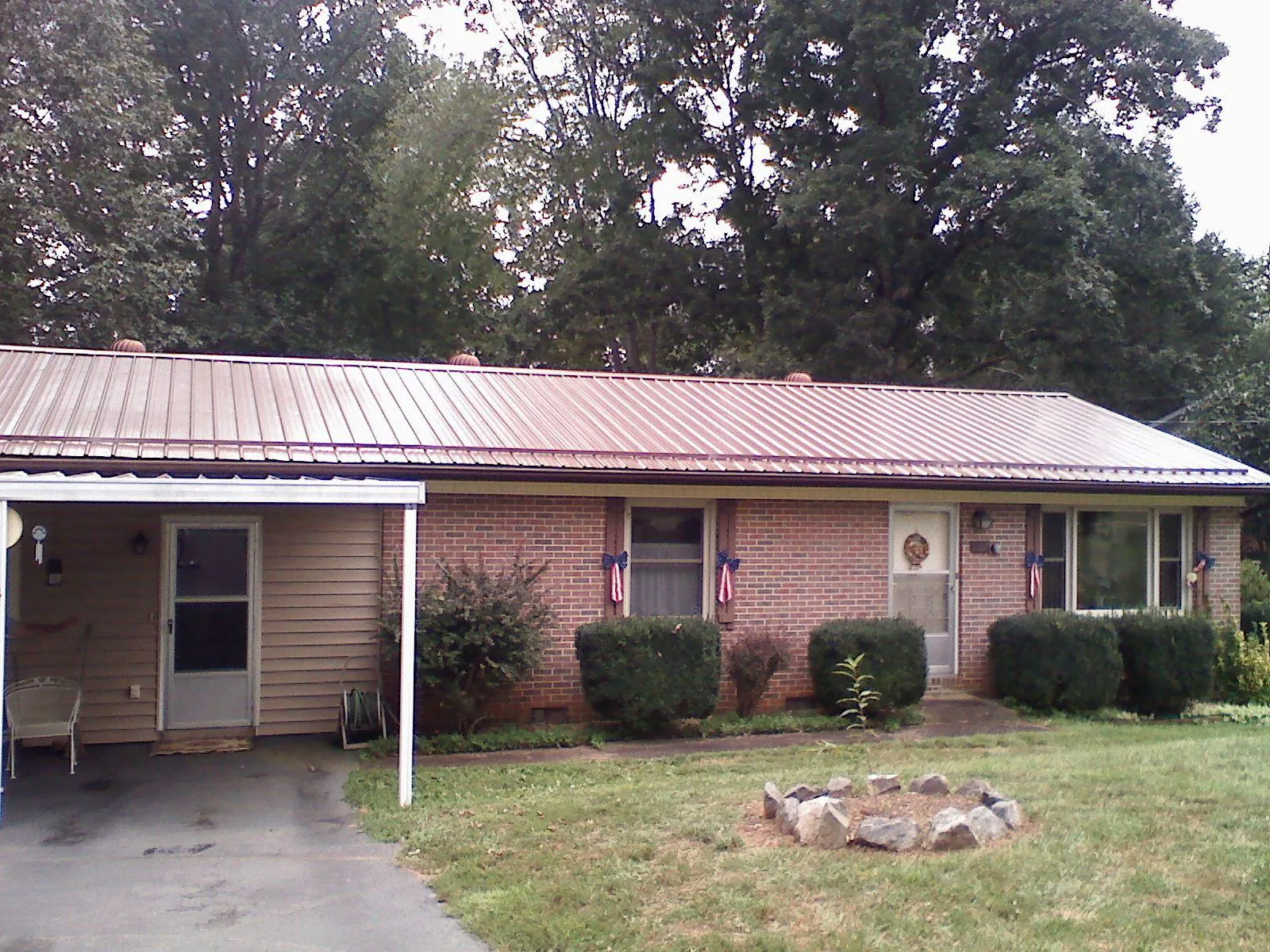 Bronze metal roof and carport on a brick ranch home — Roof Repair work by our crew in Wilson